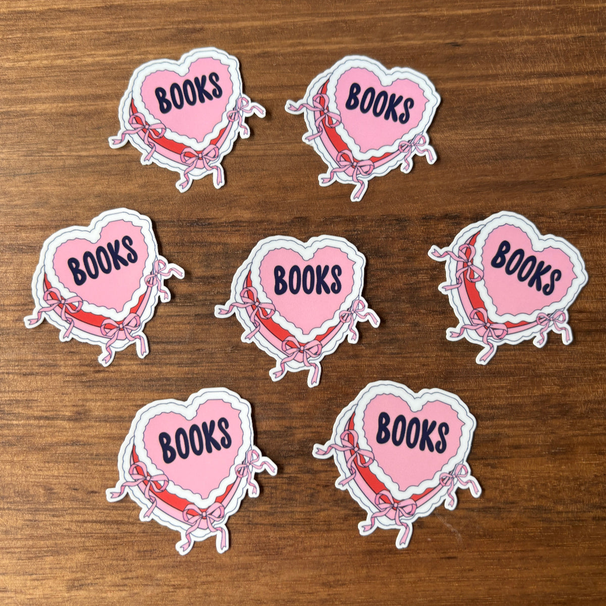 Heart-shaped stickers with 'BOOKS' text on a wooden surface