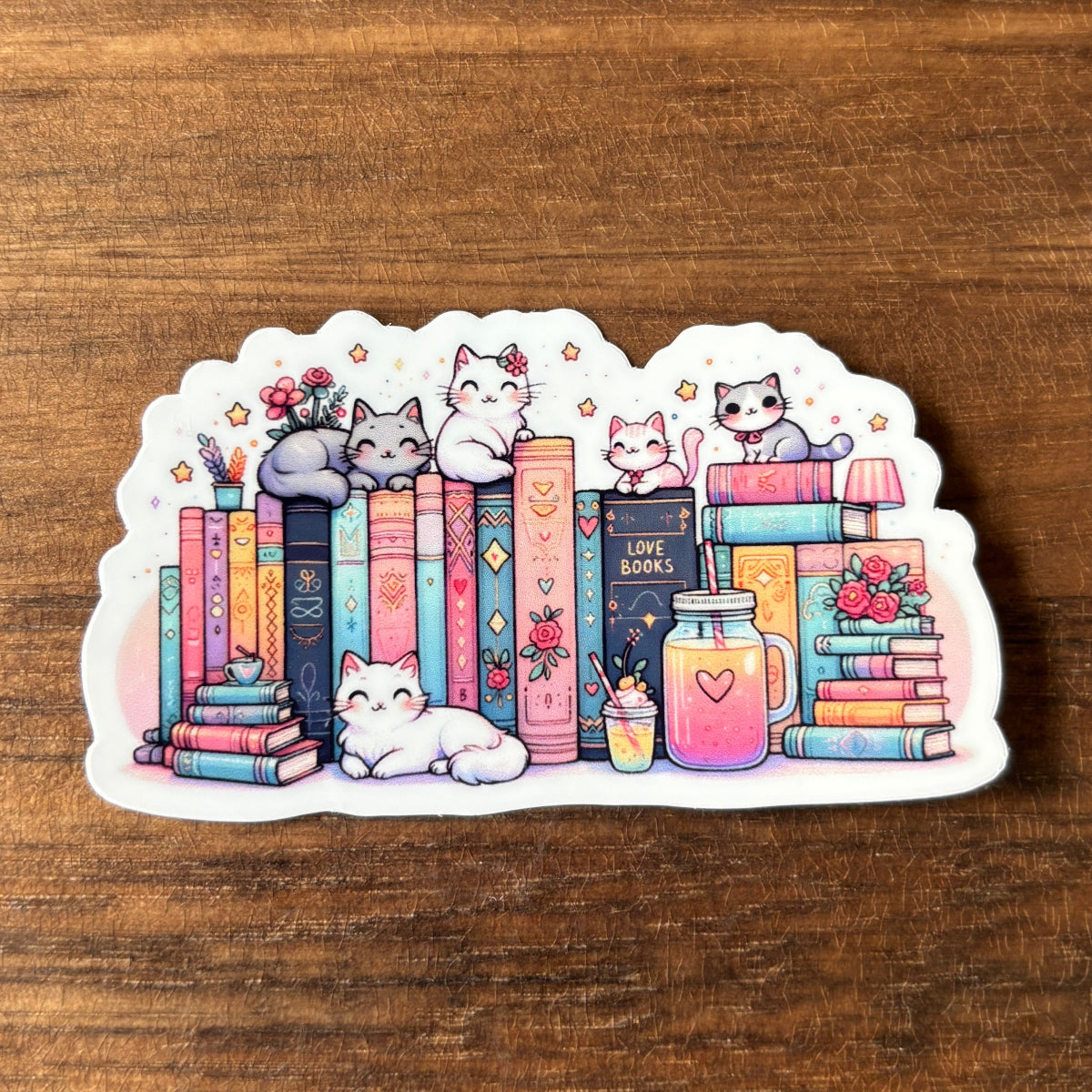 Sticker with cartoon cats and books on a wooden surface