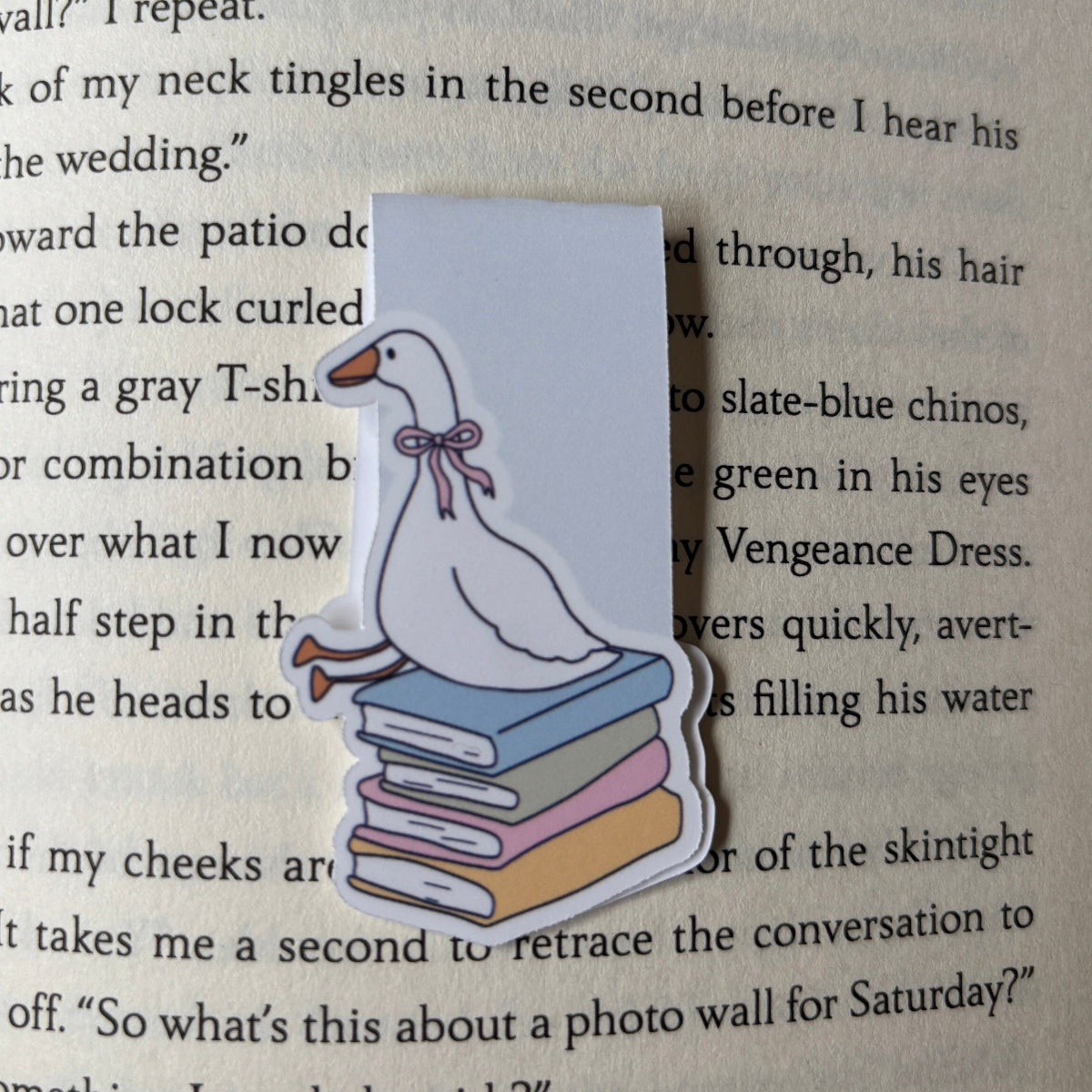 Bookmark with a cartoon goose on a stack of books on a book page