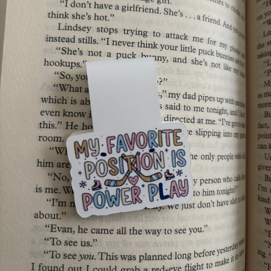 Colorful 'My Favorite Position is Power Play' magnetic bookmark on a book page