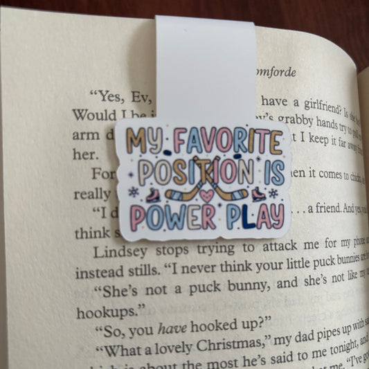 Colorful magnetic bookmark with text 'My Favorite Position is Power Play' on an open book.